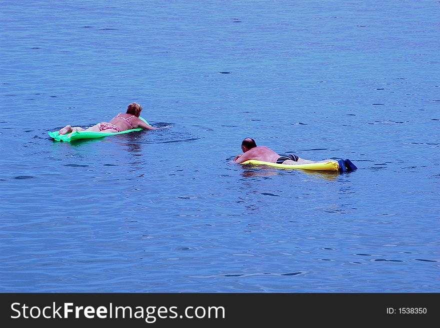 Woman and men floating on the sea at beach. Woman and men floating on the sea at beach