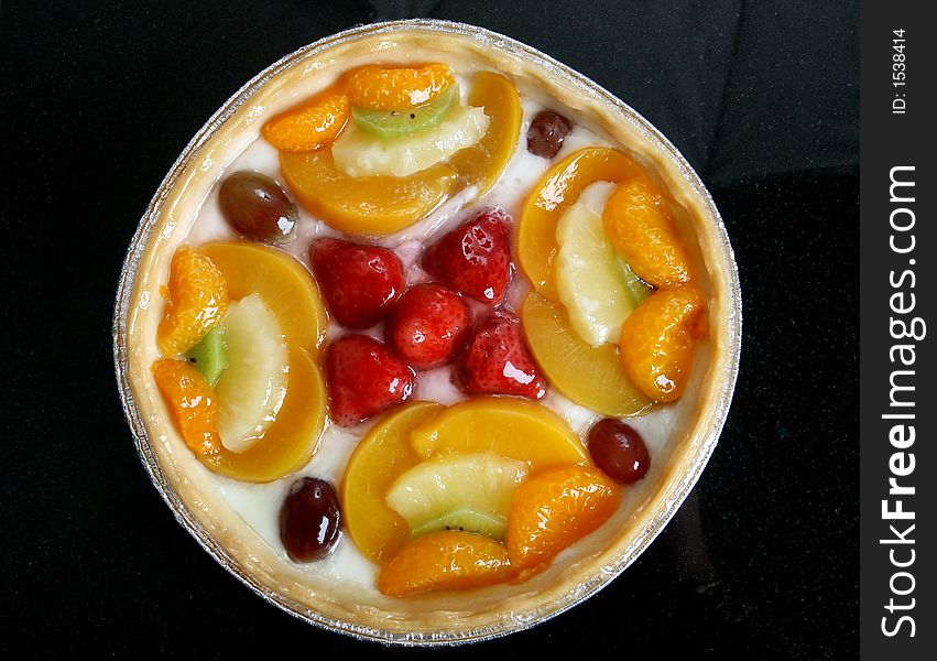 Summer garden fruits in a sweet glazed cream pie dessert, macro close up with copy space