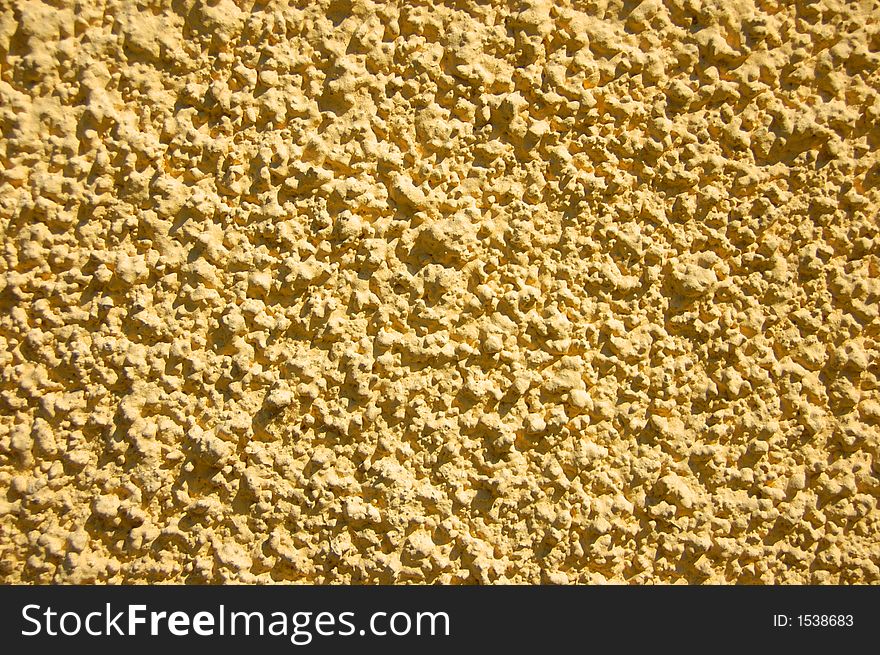 Yellow plaster texture from near house