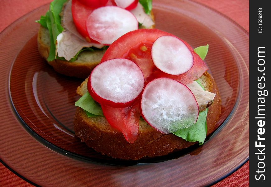 Fresh spring time sandwiches: bread, butter, lettuce, pork, tomato, radish