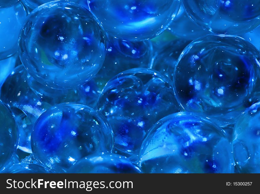 Close up of bright blue marbles with reflections of light