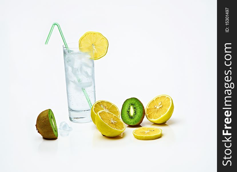 A glass of iced lemonade or water,sliced lemons and kiwi