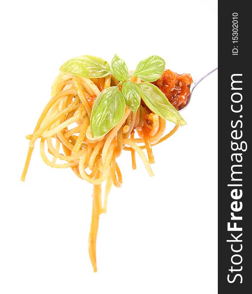 Spaghetti with sauce bolognese hanging on a fork decorated with fresh basil. Spaghetti with sauce bolognese hanging on a fork decorated with fresh basil