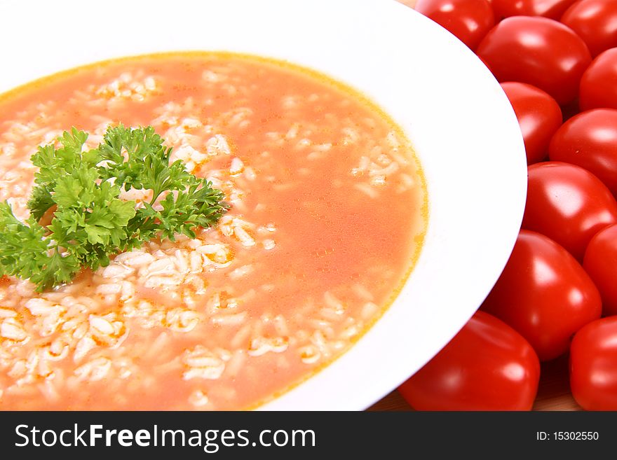 Tomato soup with rice decorated with parsley with fresh tomatoes