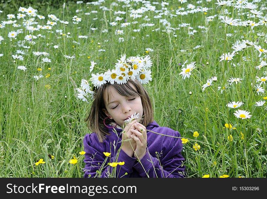 Happy girl smelling and feeling flowers