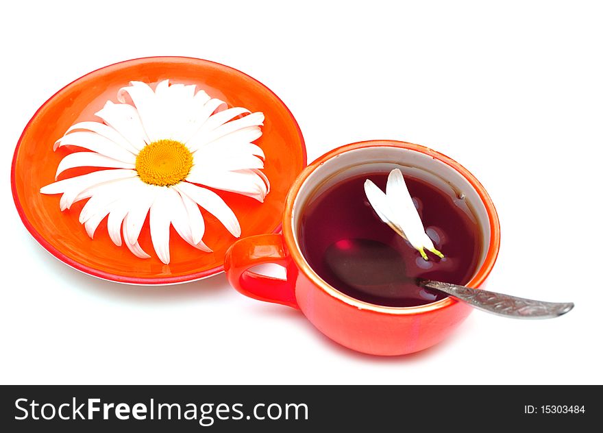 Orange cup tea  and camomiles at the background