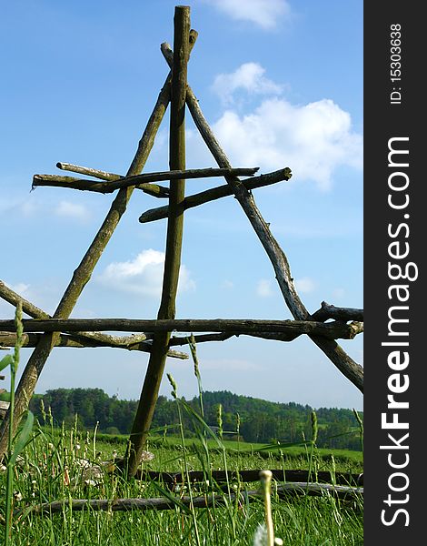 Rural landscape in Malopolska (Poland). Wooden construction for curing hay stacks