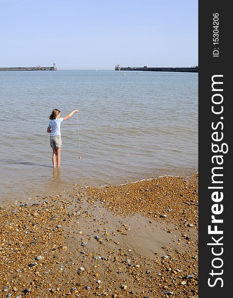 Caucasian child having fun in water, entrance in english channel and blue sky in background. Caucasian child having fun in water, entrance in english channel and blue sky in background