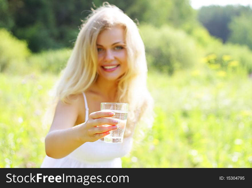 Girl with a glass of water in nature