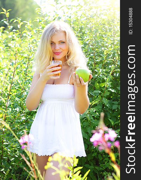 Beautiful girl is holding an apple and juice. Beautiful girl is holding an apple and juice