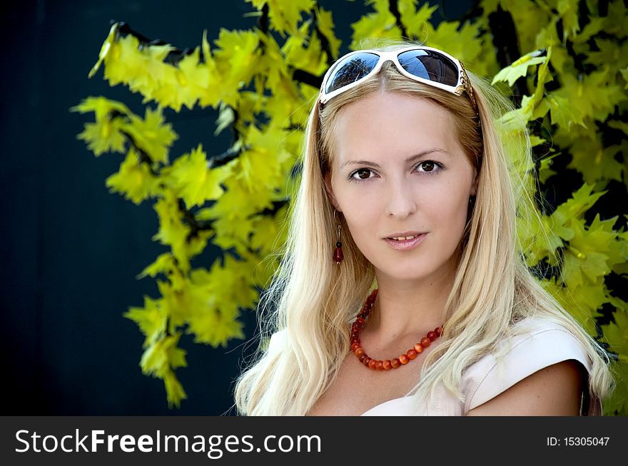 Luxury blonde woman in sunglasses looks in a shot. Earrings, a beads on a neck. Luxury blonde woman in sunglasses looks in a shot. Earrings, a beads on a neck