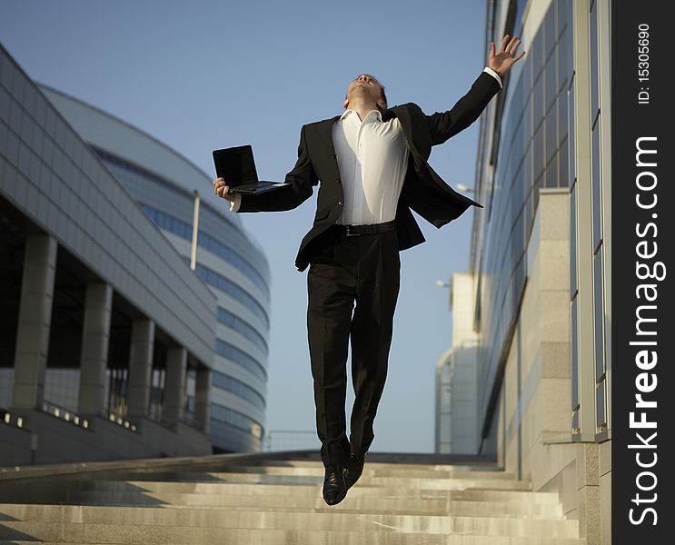 Jumping businessman over urban background. Jumping businessman over urban background