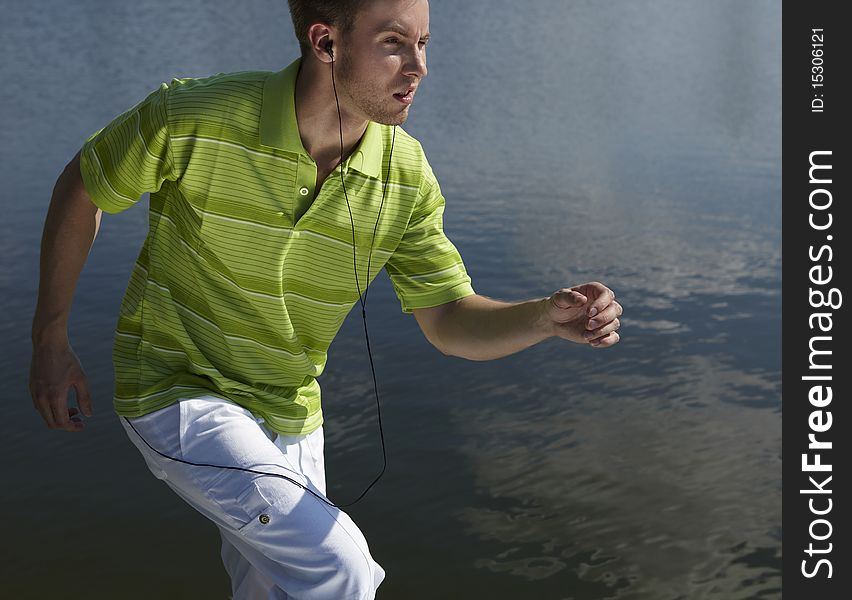 Cheerful guy in a green vest. Photo on water background.