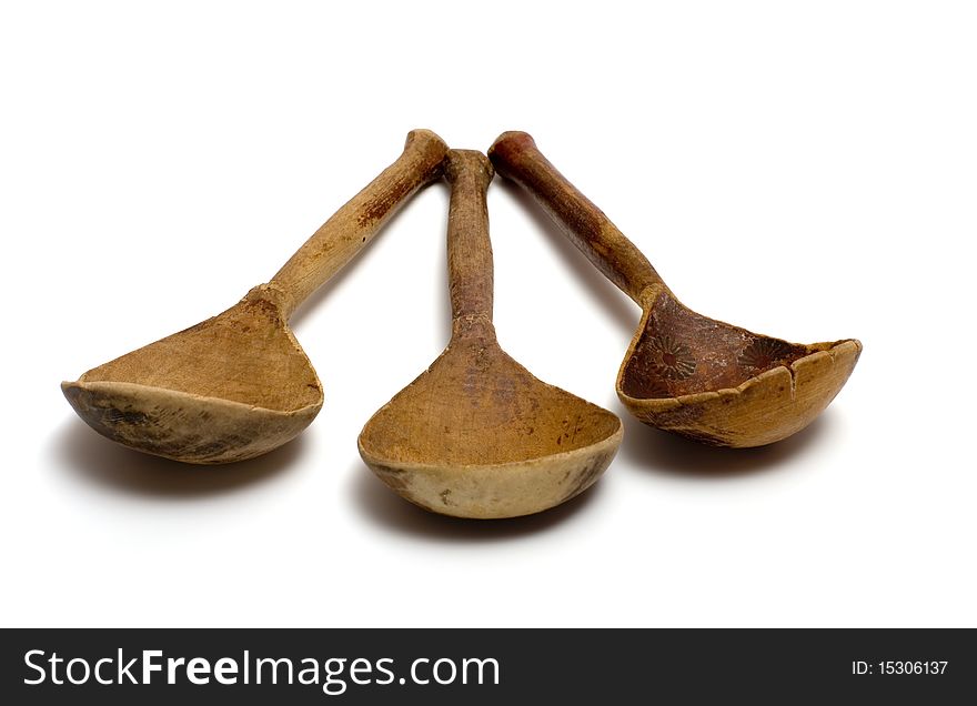 Three ancient wooden spoons on a white background. Three ancient wooden spoons on a white background.