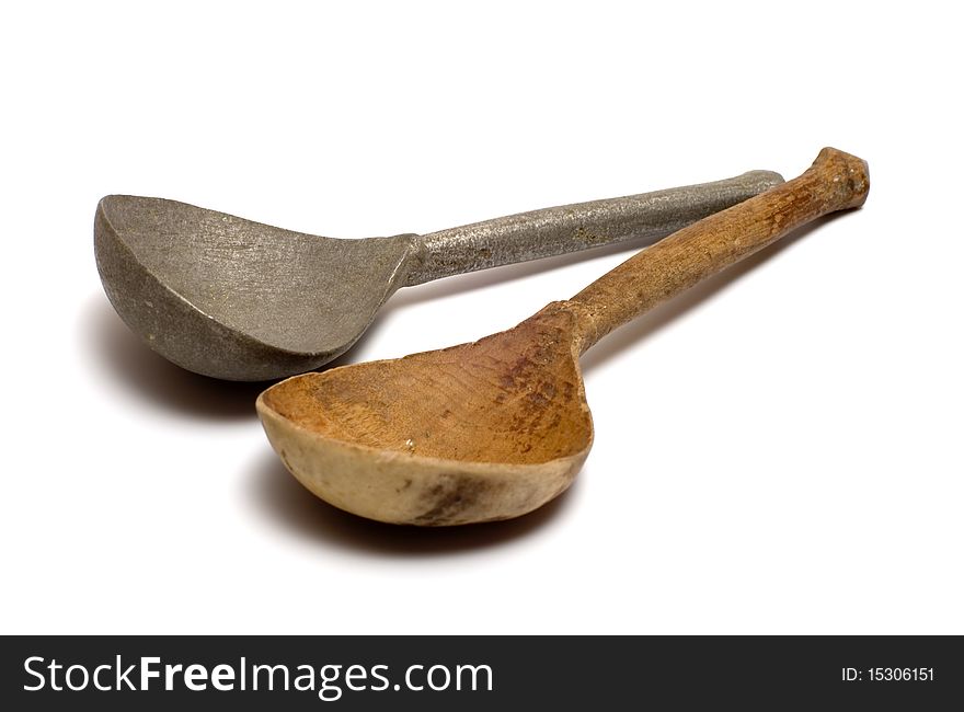 Wooden and antique pewter spoons on a white background. Wooden and antique pewter spoons on a white background.