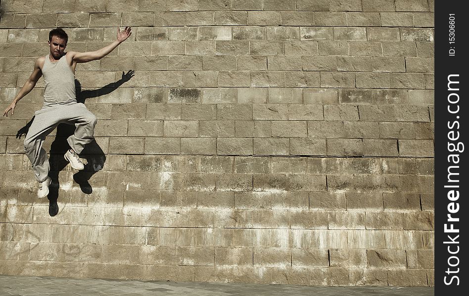 Young street acrobat makes a difficult jump. Young street acrobat makes a difficult jump