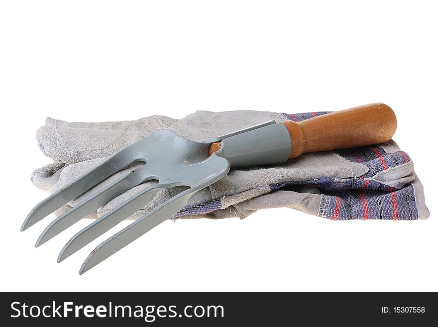 Rake for removal of weeds and a glove for work in a garden.