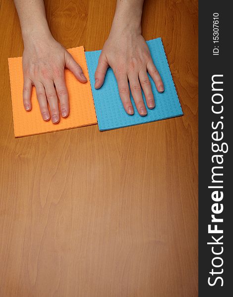 Hand with a cellulose sponge, table