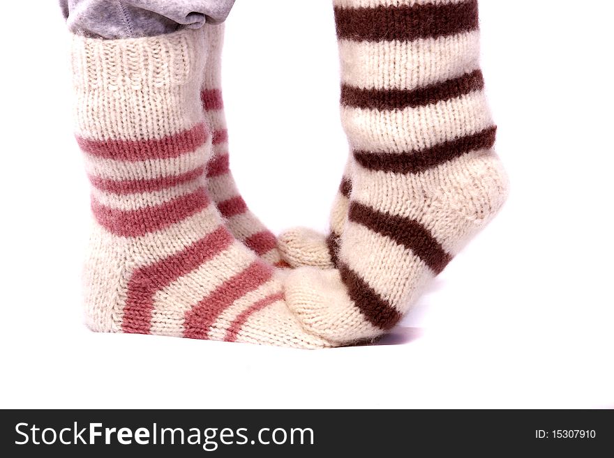 Two pair of feet wearing striped knitted socks