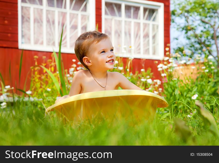 Bathing of the child in a yellow plastic bath