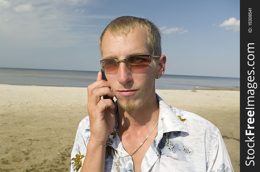 Man talking with mobiles phone on the beach. Man talking with mobiles phone on the beach.