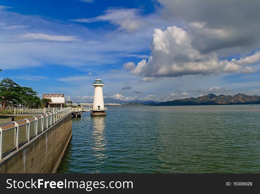 The sun shine, white lighthouse in the water, reflecting scenery and charming, In front of the mountain, is Hong Kong border