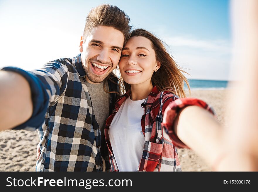 Happy young loving couple outside in free alternative vacation camping take selfie by camera