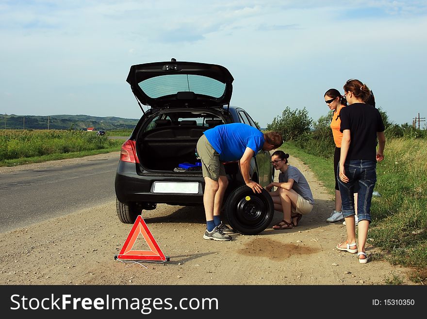 People Trying To Fix A Flat Tire