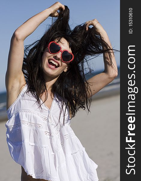 Portrait of happy young woman with stylish sunglasses playing with her hair. Portrait of happy young woman with stylish sunglasses playing with her hair