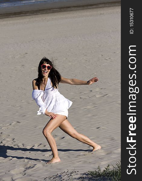 Happy young atractive woman is dancing on the beach. Happy young atractive woman is dancing on the beach