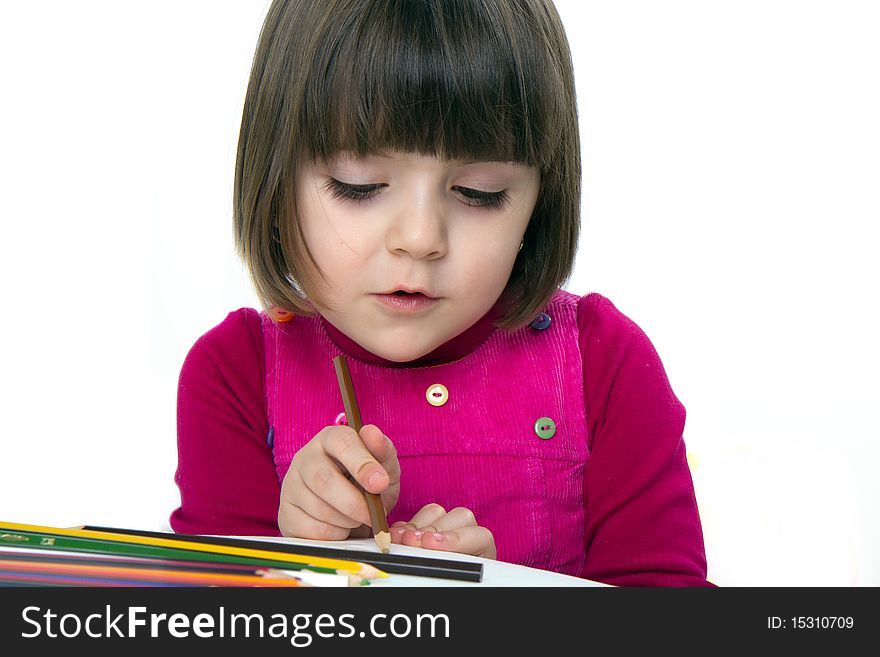 3 years old girl drawing with colored pencils, focused on the details, not looking at the camera. Studio shot. 3 years old girl drawing with colored pencils, focused on the details, not looking at the camera. Studio shot.