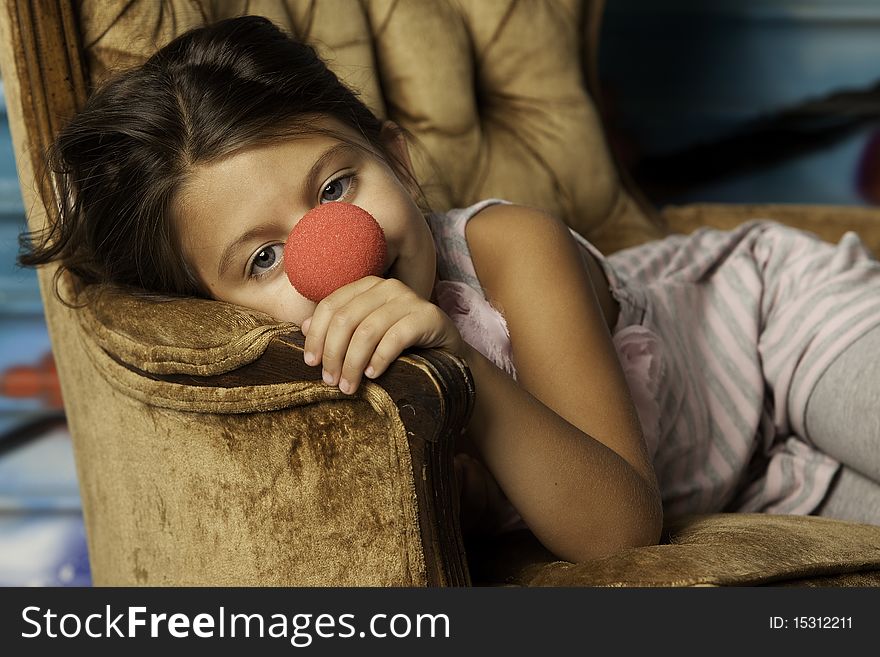 Girl in chair with clown nose
