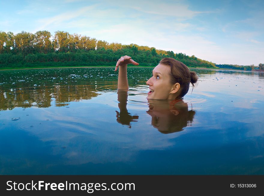 Beautiful young girl with a bright emotions swimming in the river