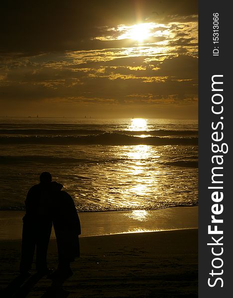 Couple standing before the ocean sunset. Couple standing before the ocean sunset.