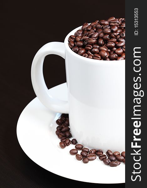 Coffee mug filled with fresh coffee beans
