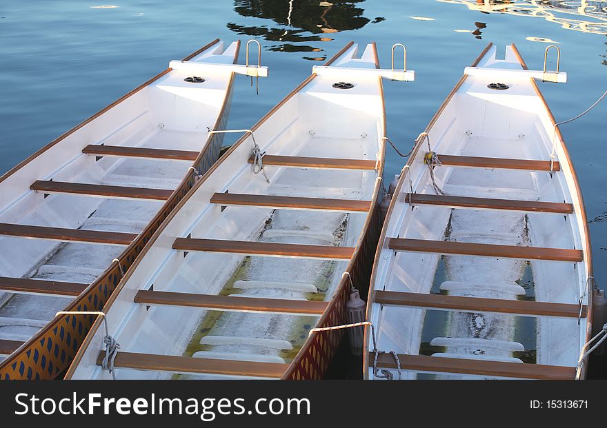 Three Paddle Boats In A Row At A Dock