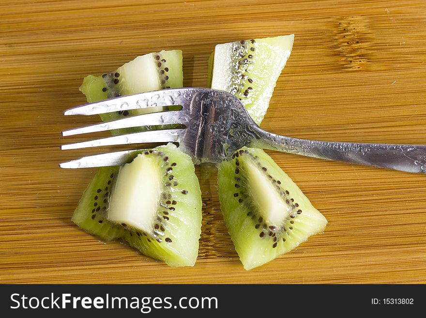 Kiwi  and fork on the wood background