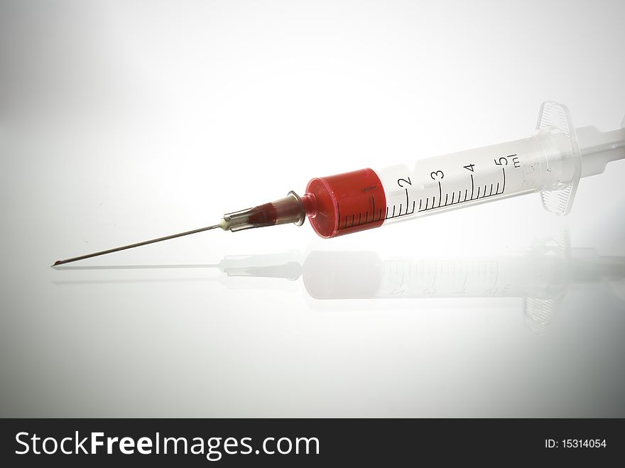 Photo of Medical Syringe on glossy background