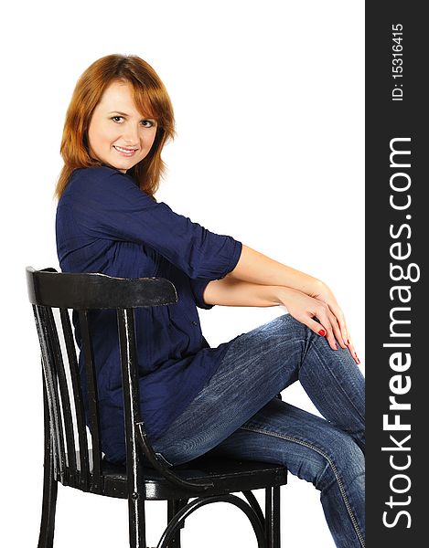 Portrait of beautiful smiling brown-eyed girl sitting on chair, isolated on white