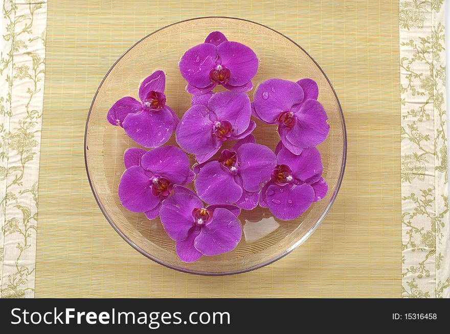 Bowl of orchid floating in a bowl of water on mat. Bowl of orchid floating in a bowl of water on mat