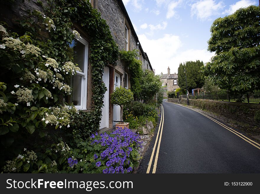 Climbing plant covered roadside cottage in Yorkshire Dales