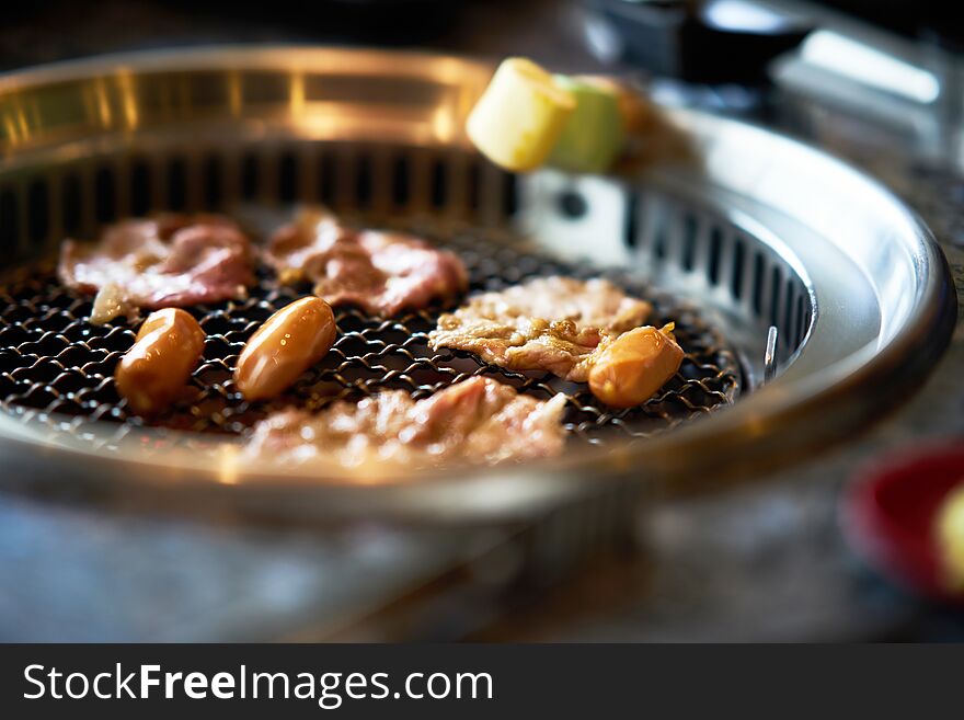 Grilling sliced pork ,sausages and Marshmallows on asian grill style