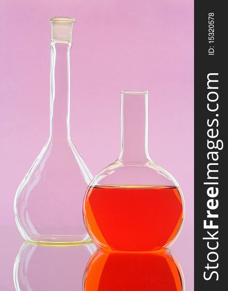 Two chemical flasks on a colour background