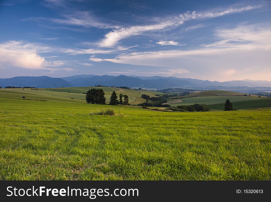 Meadows in sunset scenery with cloudy sky. Meadows in sunset scenery with cloudy sky