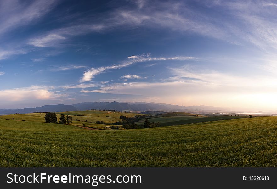 Meadows in sunset scenery panorama