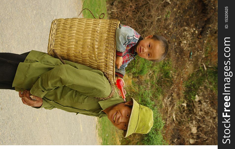 Grandfather Hmong and her small son in the cart. The road is long and the baby is tired. Grandfather Hmong and her small son in the cart. The road is long and the baby is tired.