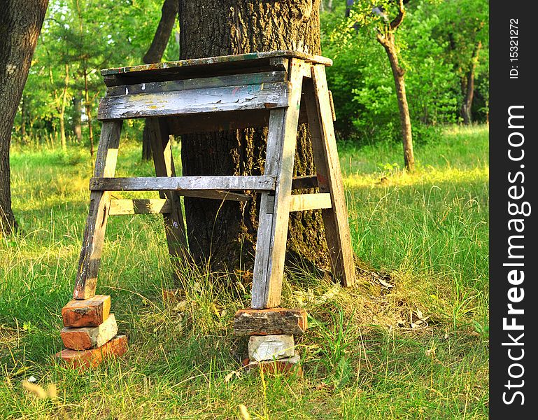 Old bench on bricks is put to tree