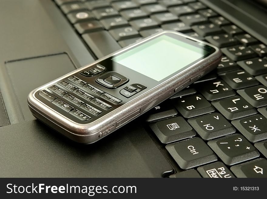 Mobile phone on a laptop.
