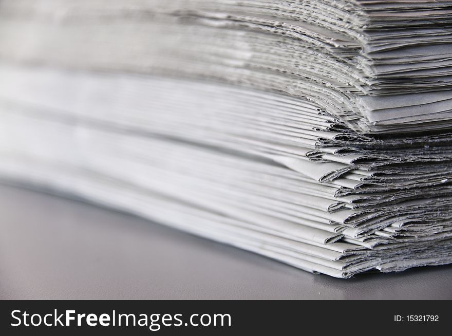 This image shows a stack of newspapers piled