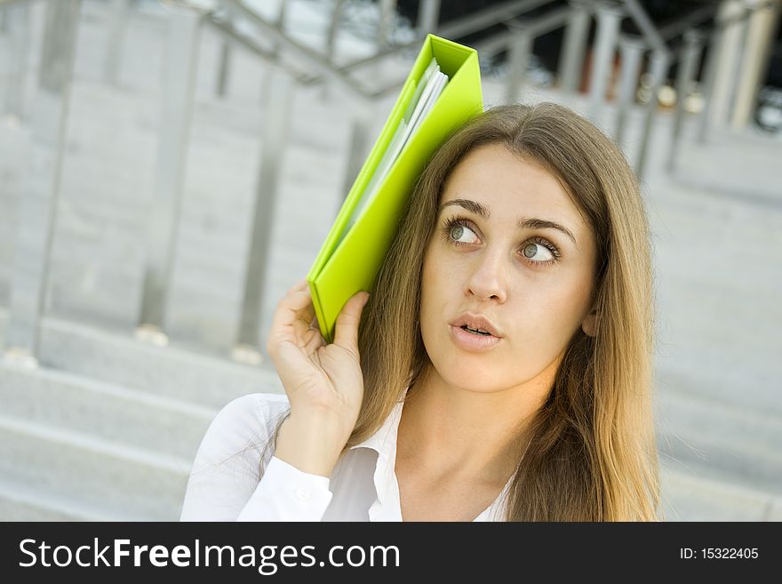 Attractive young businesswoman smiling with a green folder. Attractive young businesswoman smiling with a green folder.